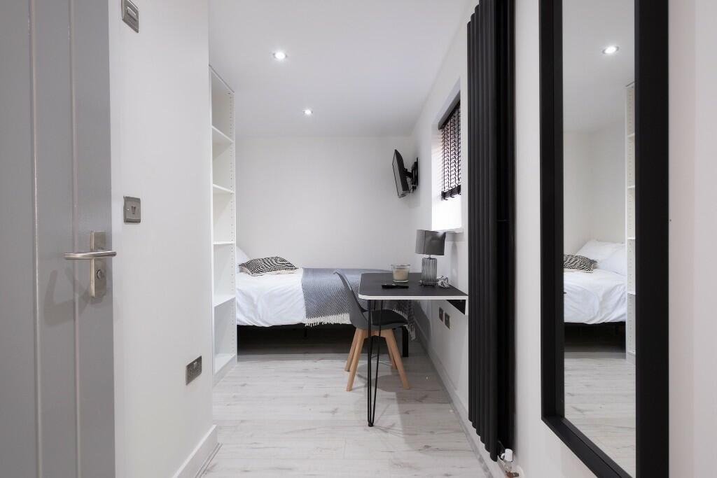 A bright and modern bedroom featuring a comfort...