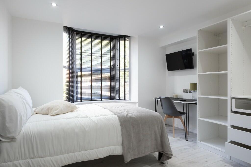A bright and spacious master bedroom featuring ...