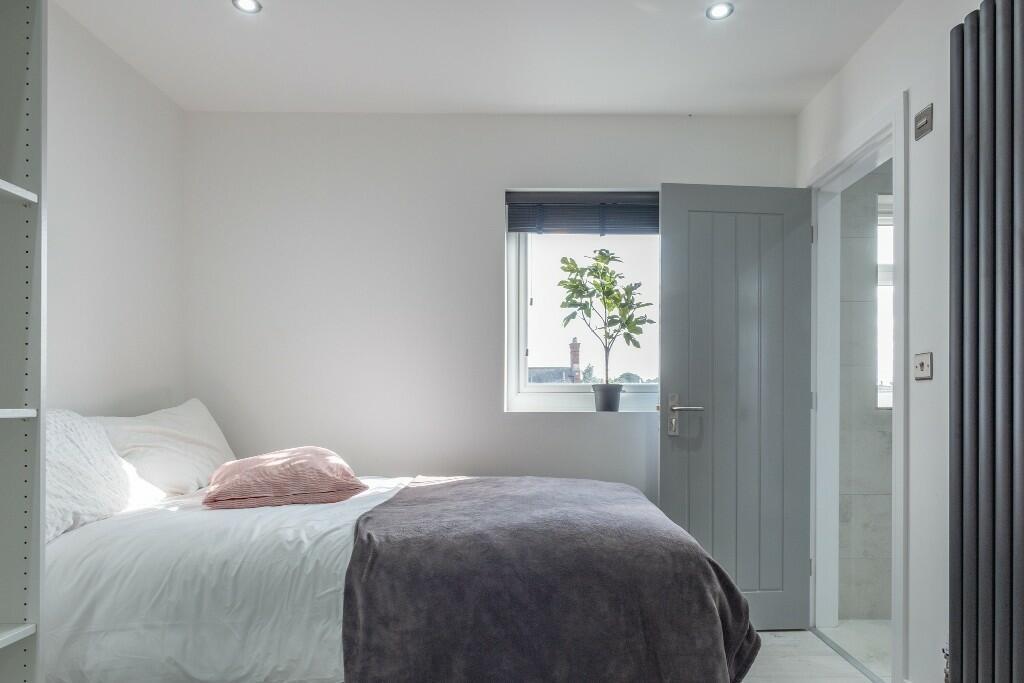 A bright and neatly presented bedroom featuring...