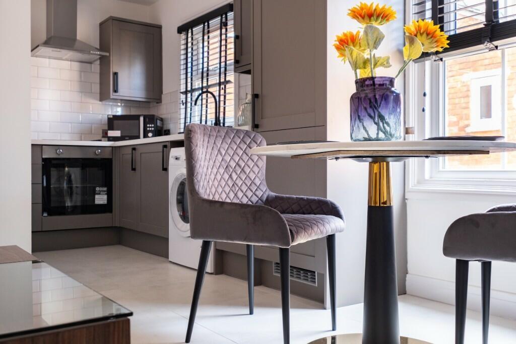 A modern, well-lit kitchen area with sleek cabi...
