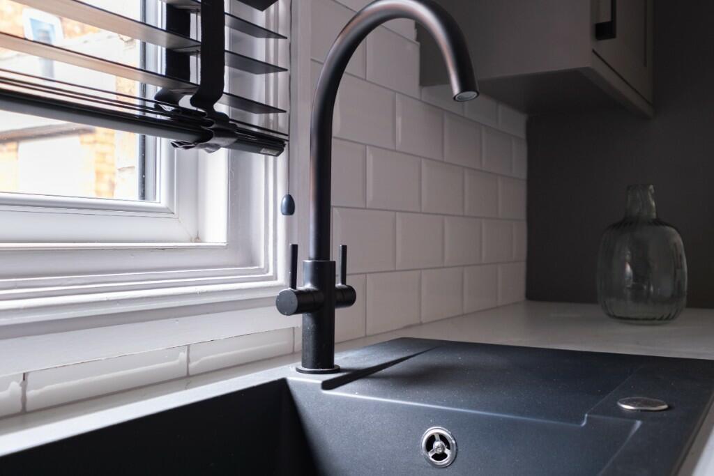 A modern kitchen space featuring a sleek sink w...