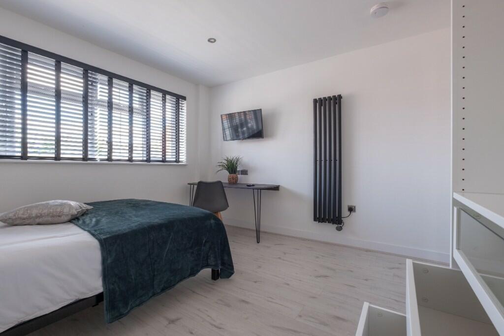 A bright and modern bedroom featuring a comfort...