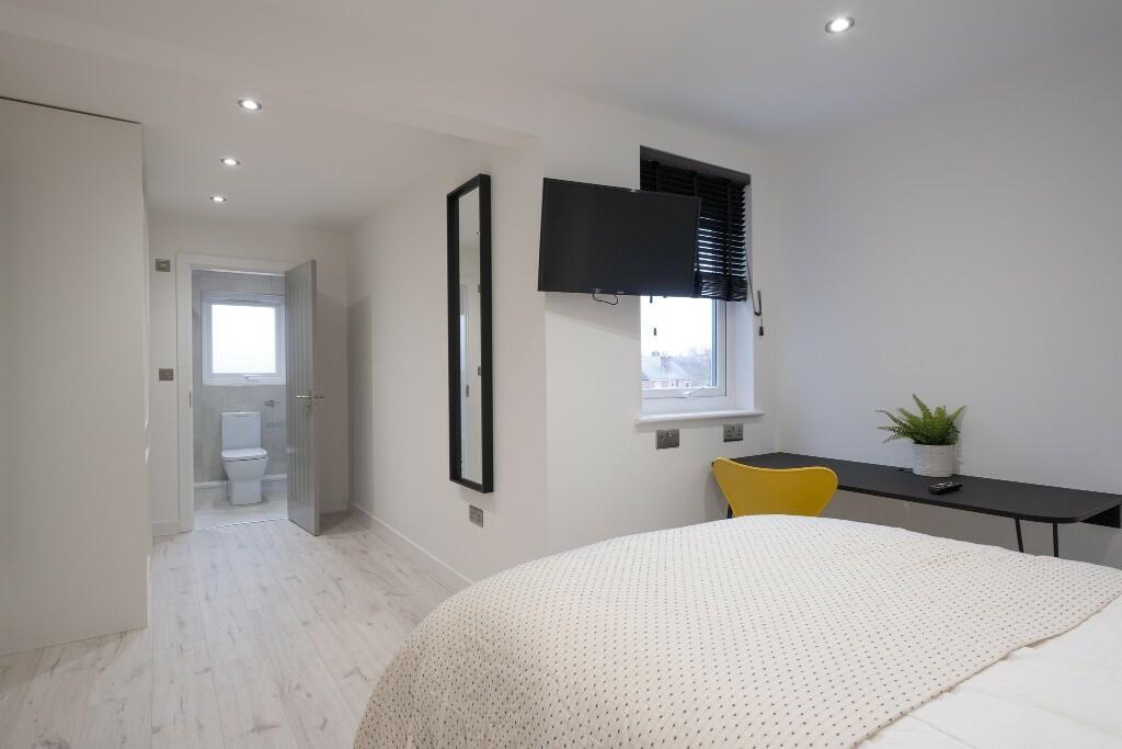 A bright and modern bedroom featuring a comfort...