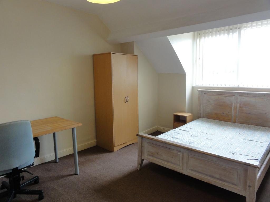 Bright and simply furnished bedroom with a doub...