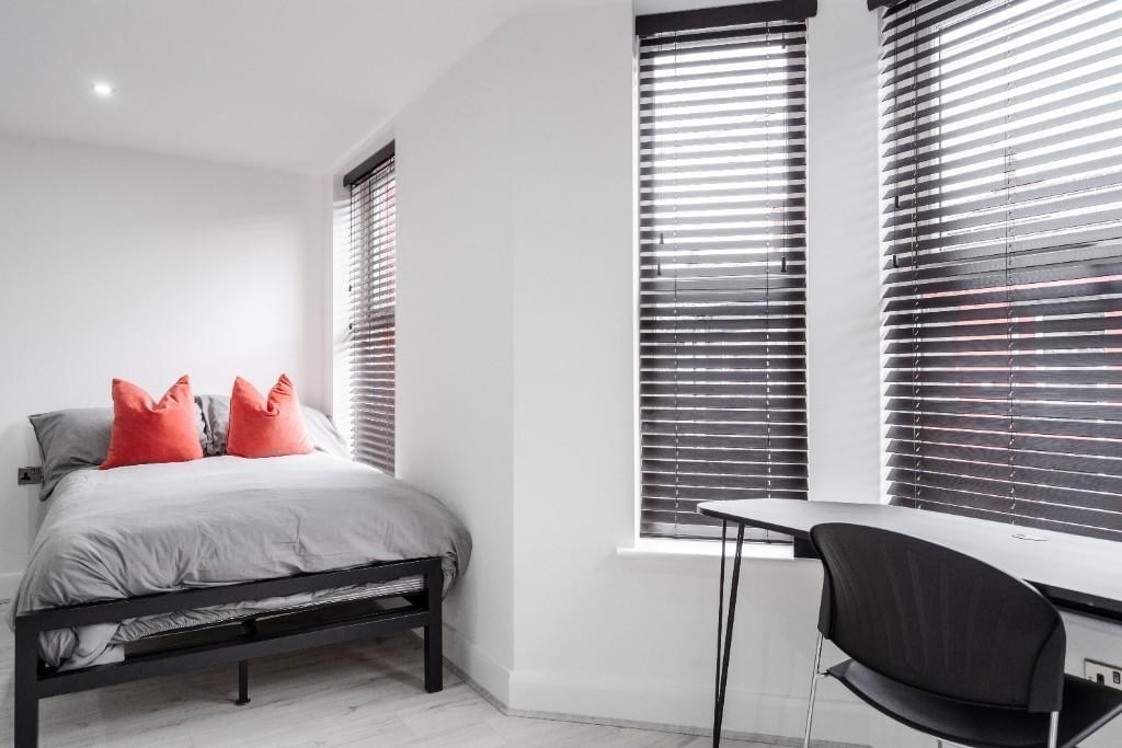Bright and modern master bedroom featuring a co...