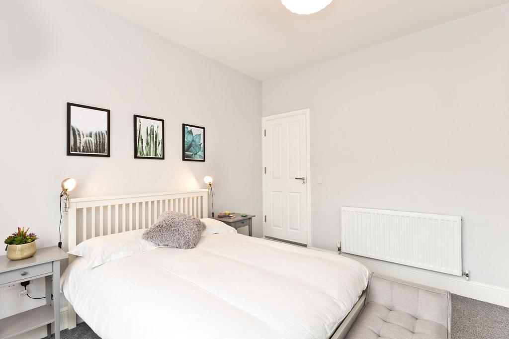 Bright, modern double bedroom with a white slat...