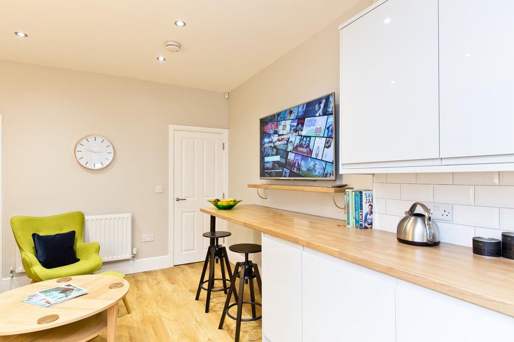 Bright, modern kitchenette with light wood coun...