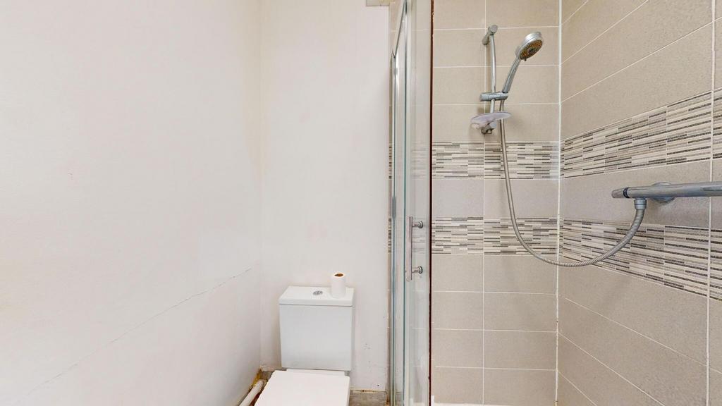 A clean, modern bathroom with a shower area fea...