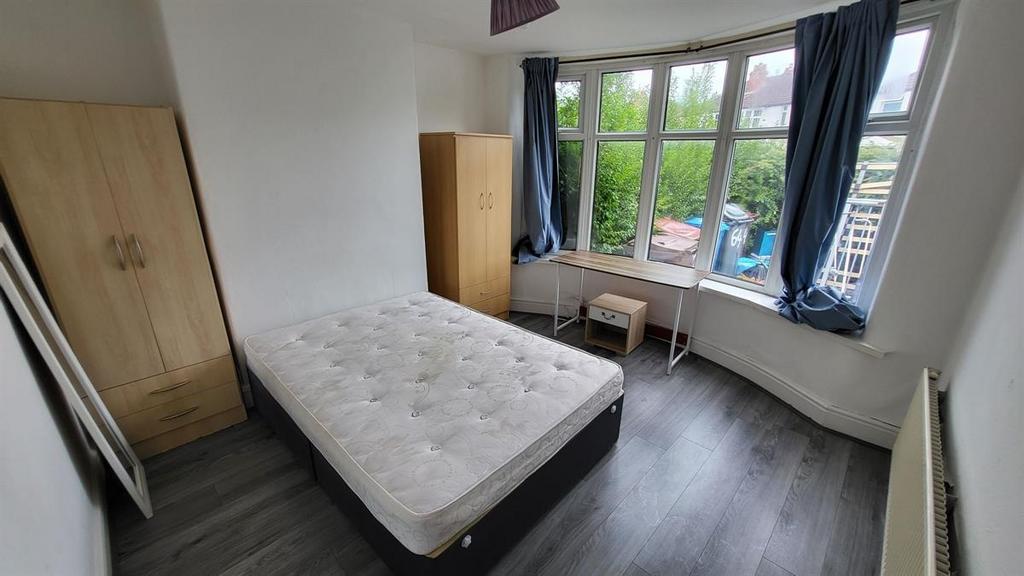 A bright, inviting bedroom featuring large wind...