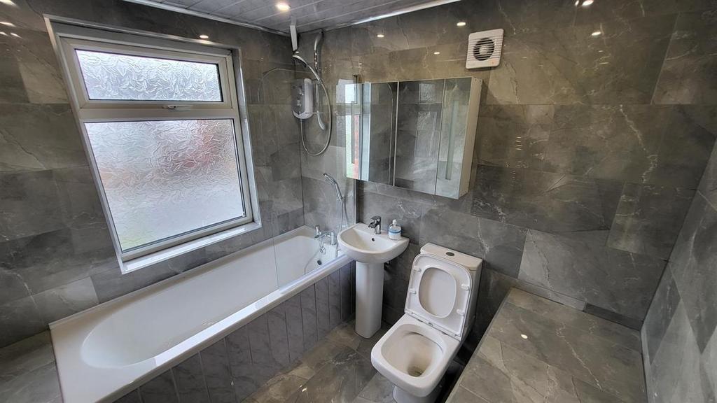 A well-maintained bathroom featuring a bathtub,...