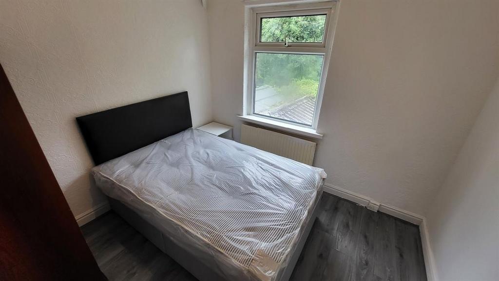A simple, tidy single bedroom with a window all...