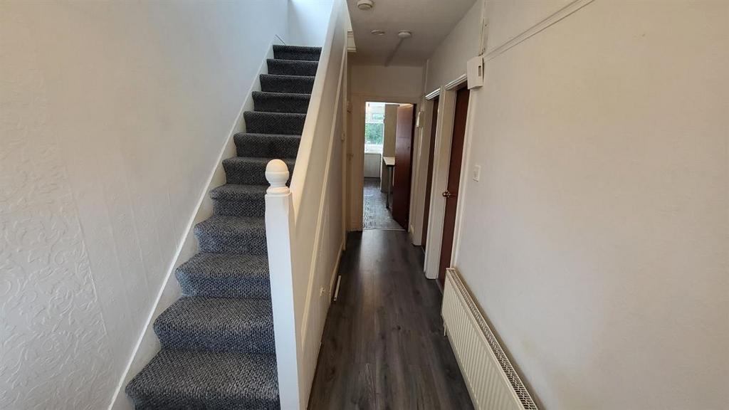 Bright, long entrance hallway with a carpeted s...