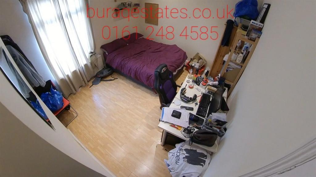 A cozy single bedroom with a bed, desk, and war...