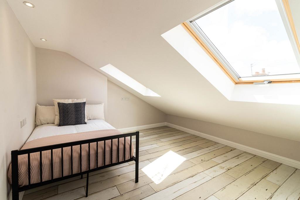 A bright and inviting bedroom featuring a cozy ...