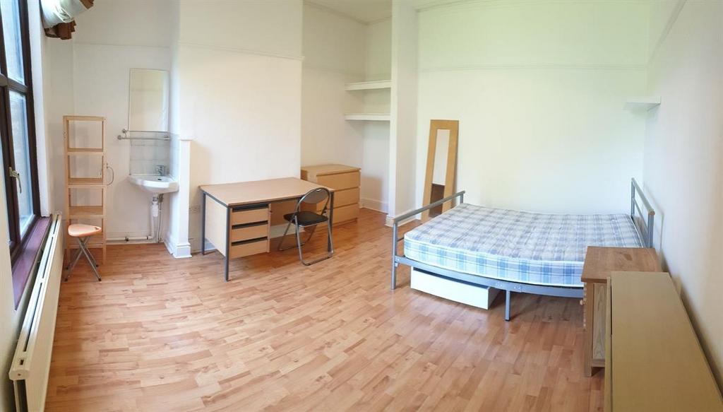A bright and clean single bedroom featuring a c...