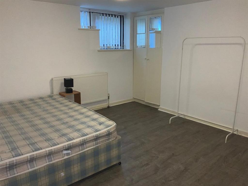 A tidy and bright bedroom featuring a comfortab...