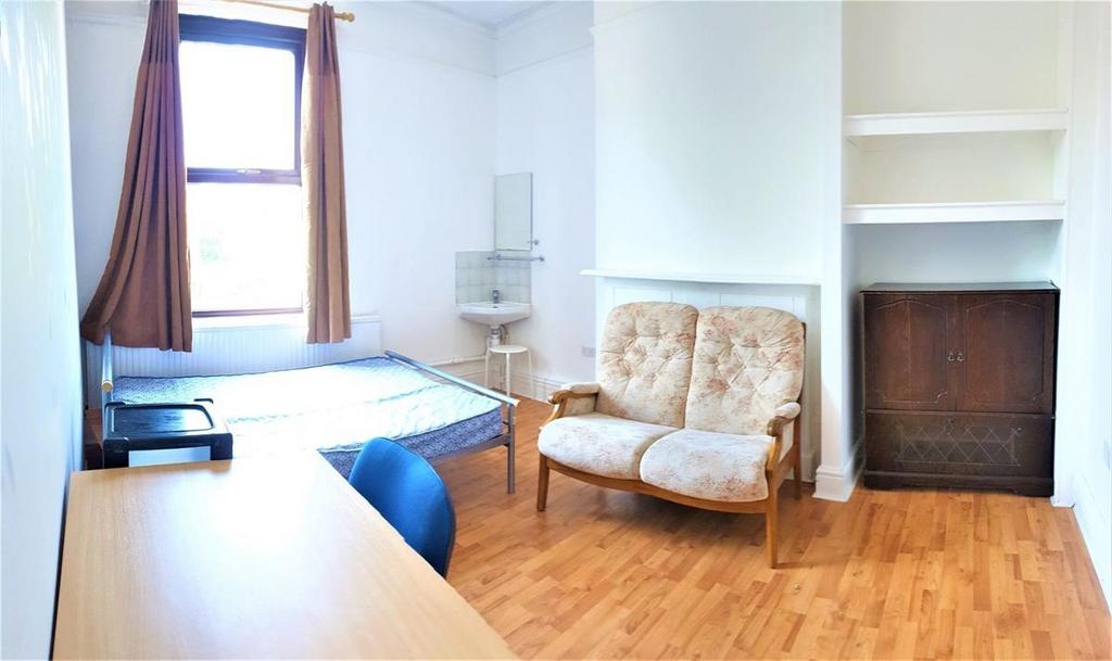 A cozy single bedroom featuring natural light f...