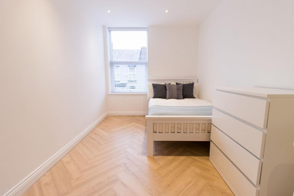 Bright, simply furnished bedroom with a neatly ...