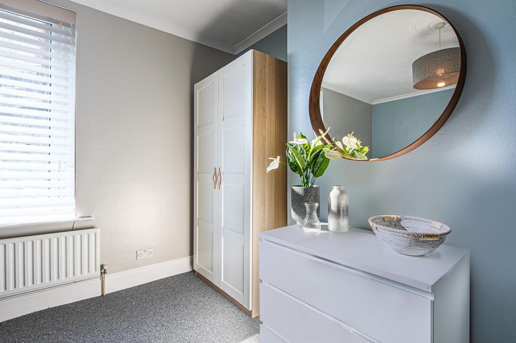 Bright, neatly styled bedroom corner with a mod...