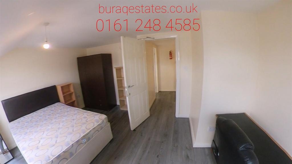 A spacious bedroom featuring a large bed, wardr...