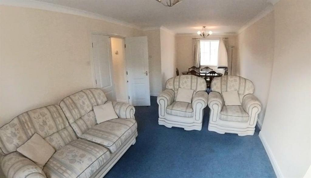 Bright, neutrally decorated living room with ma...