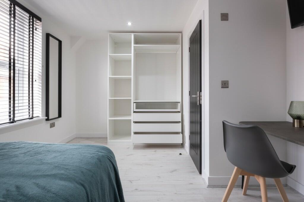 Bright and modern master bedroom featuring a co...