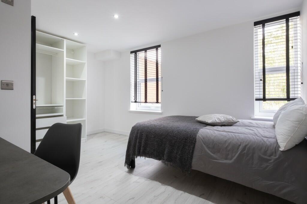 Bright and modern single bedroom featuring clea...