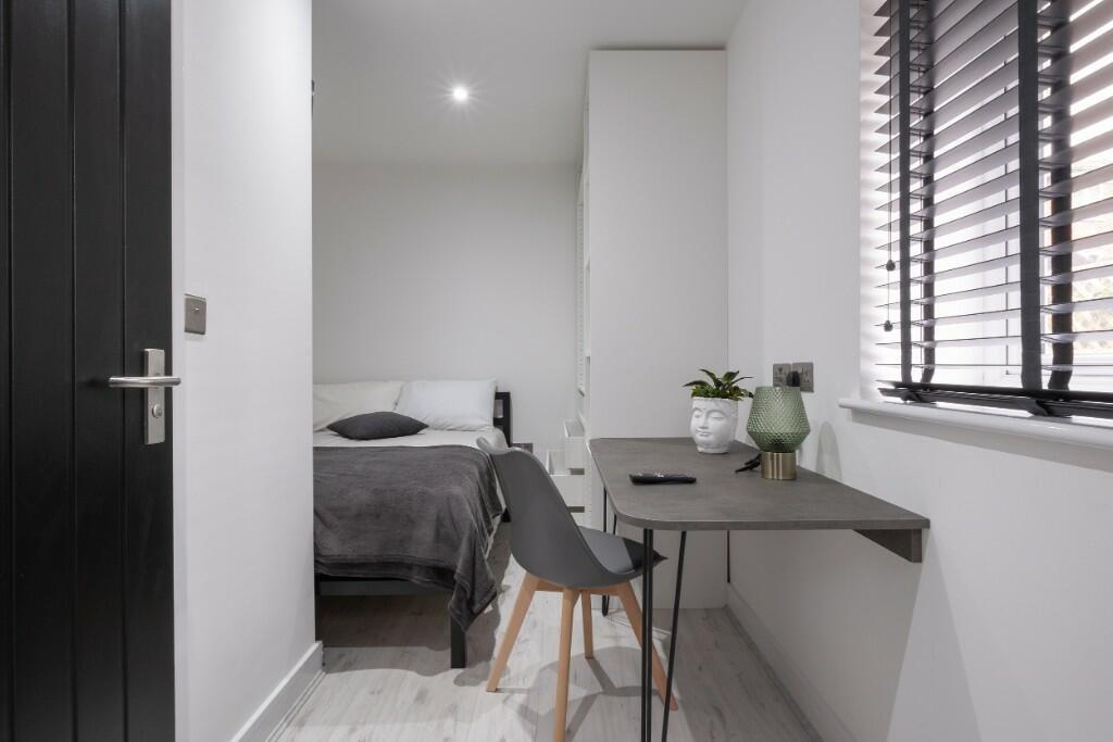 A neat and modern single bedroom featuring a co...