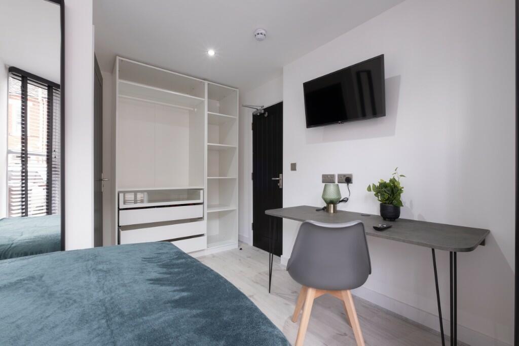 Bright and modern single bedroom featuring a co...