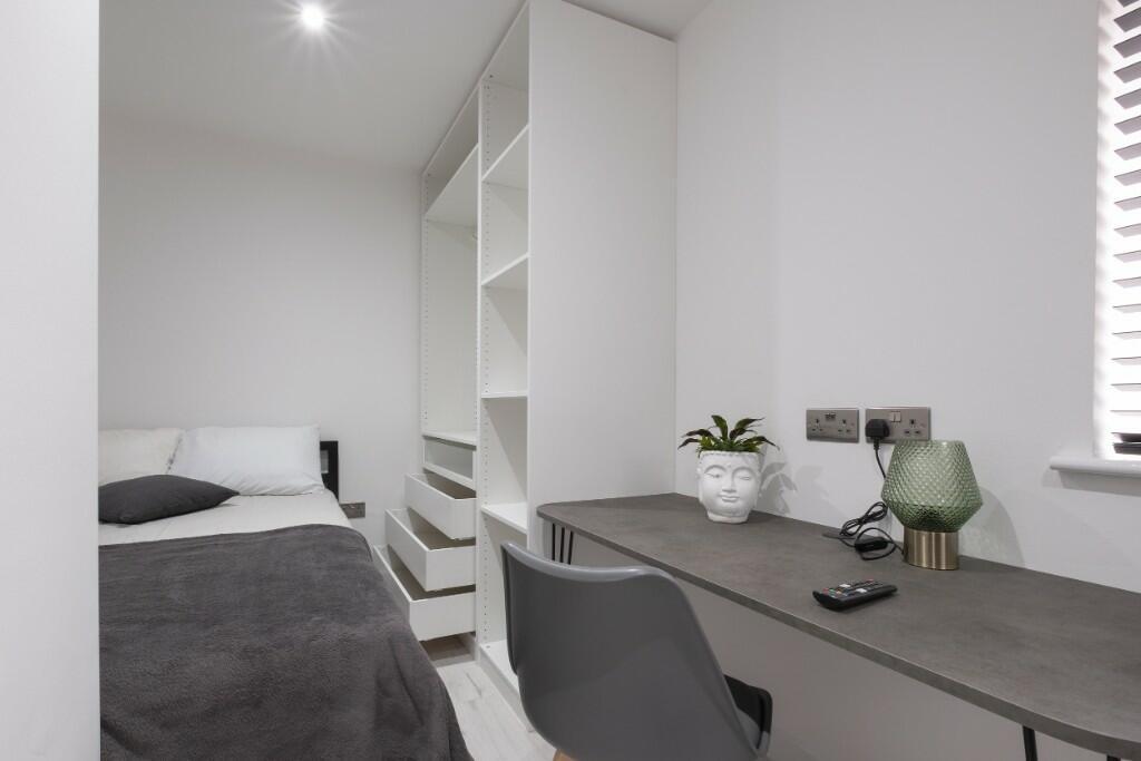 A neat and well-kept single bedroom featuring a...