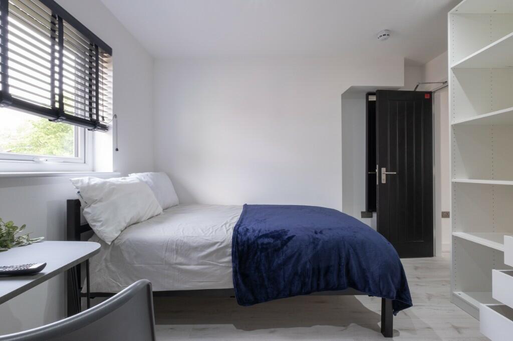 A clean and bright single bedroom featuring a n...