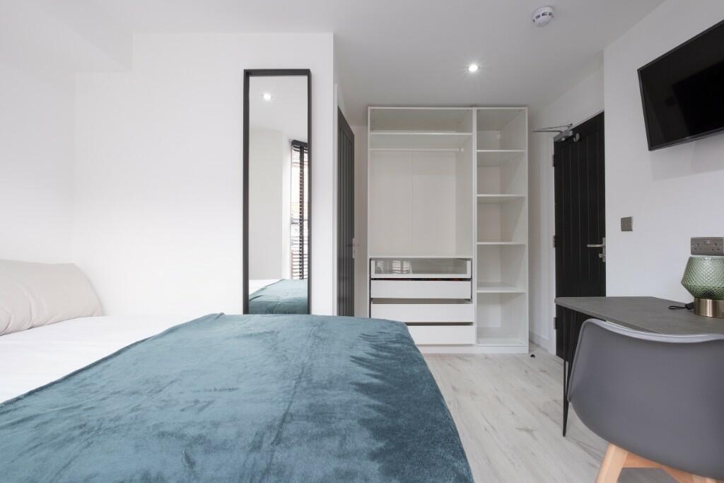 A bright and modern master bedroom featuring a ...
