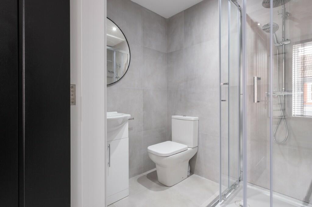 A sleek, modern bathroom featuring a spacious g...