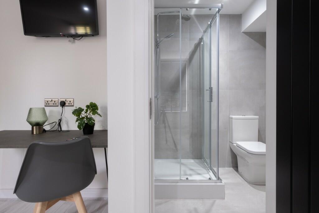 Modern bathroom featuring a glass-enclosed show...