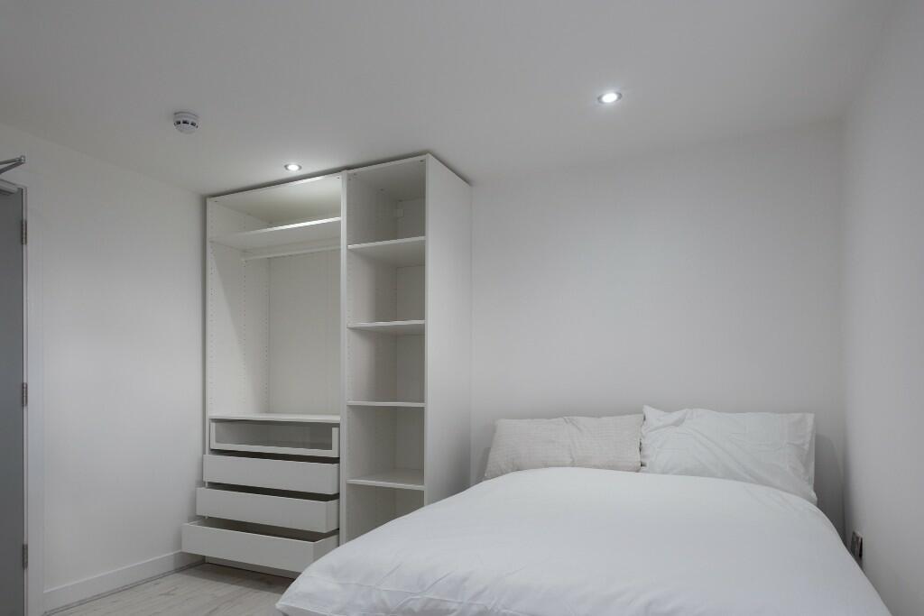 A bright and tidy bedroom featuring a comfortab...