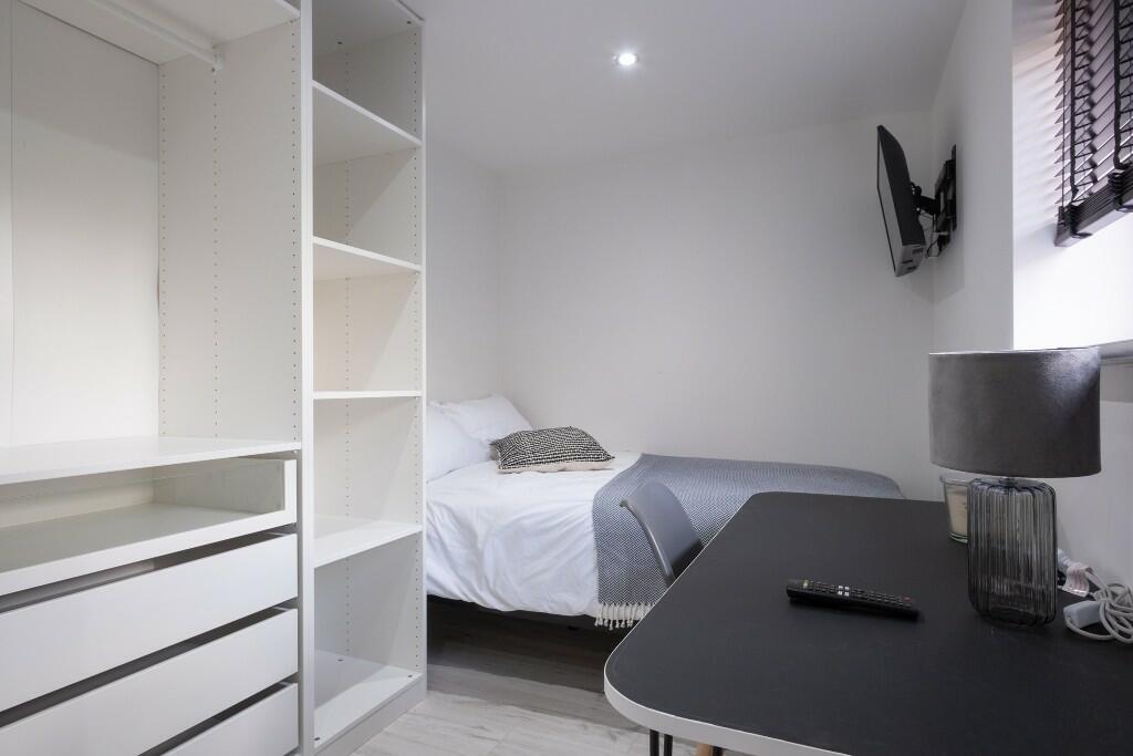 A modern and tidy bedroom featuring a comfortab...