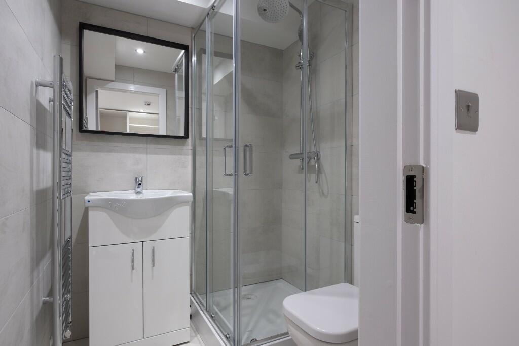 A clean and modern bathroom with a shower enclo...