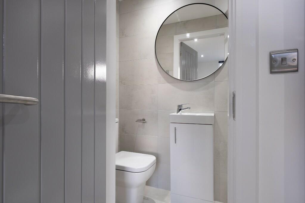 A clean and modern bathroom featuring a toilet,...