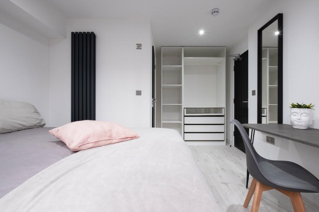 A modern, spacious master bedroom featuring a l...