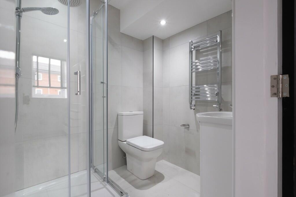 A modern, clean bathroom featuring a large show...