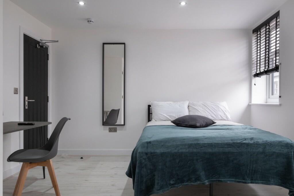 A spacious and modern master bedroom featuring ...