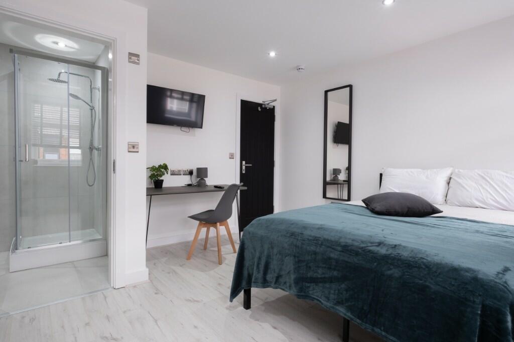 Bright and modern bedroom featuring a comfortab...