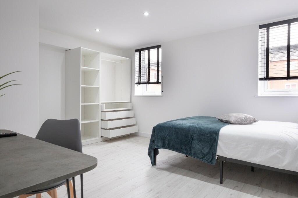 A bright and modern bedroom featuring a large b...
