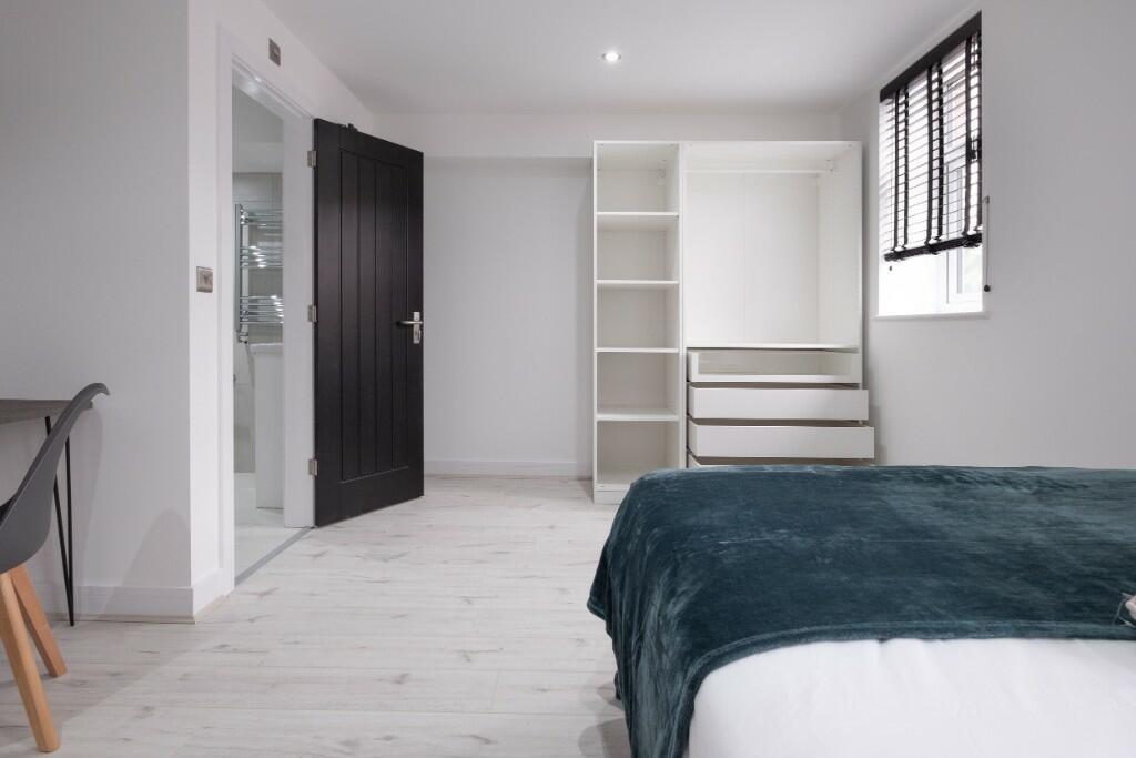 A bright and tidy bedroom with a neatly made be...