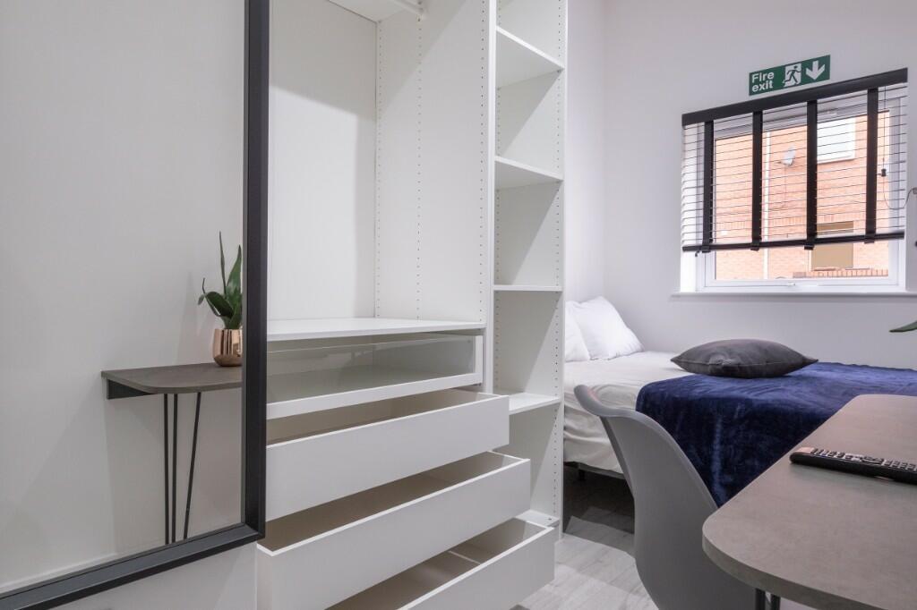 A cozy bedroom featuring a neatly made bed, amp...