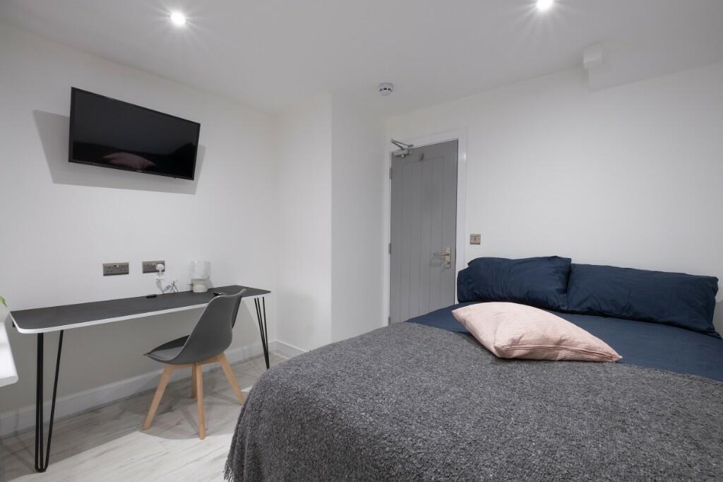 A spacious and modern master bedroom featuring ...