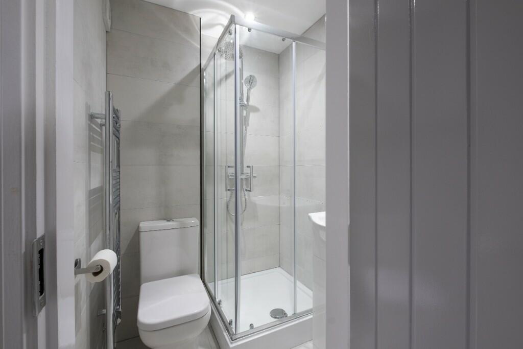 A modern, clean bathroom featuring a large show...