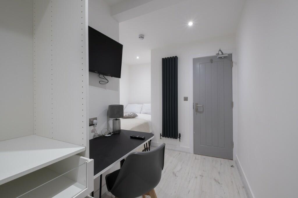 A well-maintained student bedroom featuring a c...