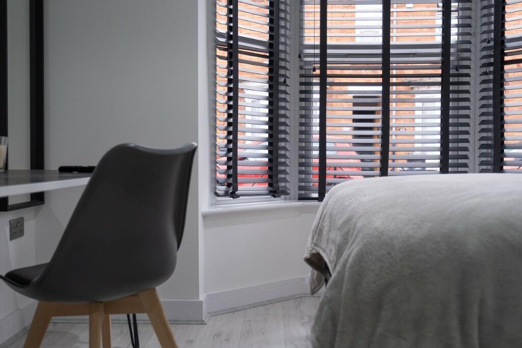 A bright and modern bedroom featuring a neatly ...