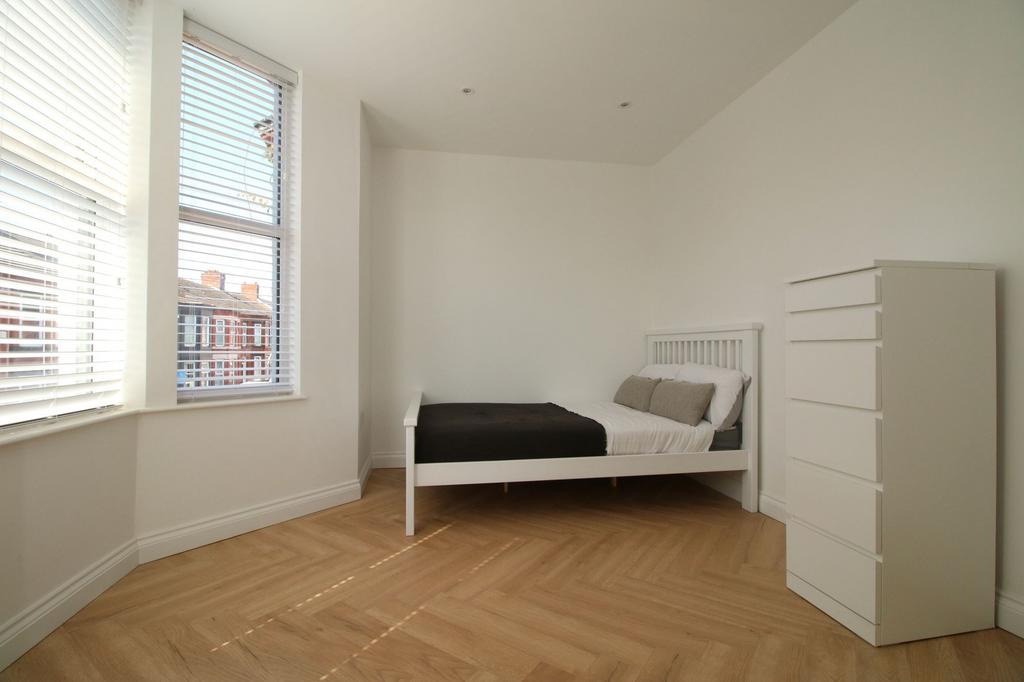 Bright, minimalist bedroom with large bay windo...